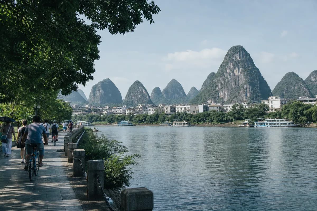 Guilin's Li River waterfront with karst hills beyond the city.
