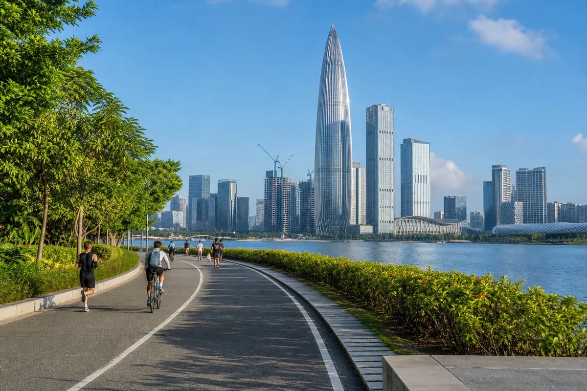 Cyclists and walkers beside Shenzhen Bay with the Nanshan skyline ahead