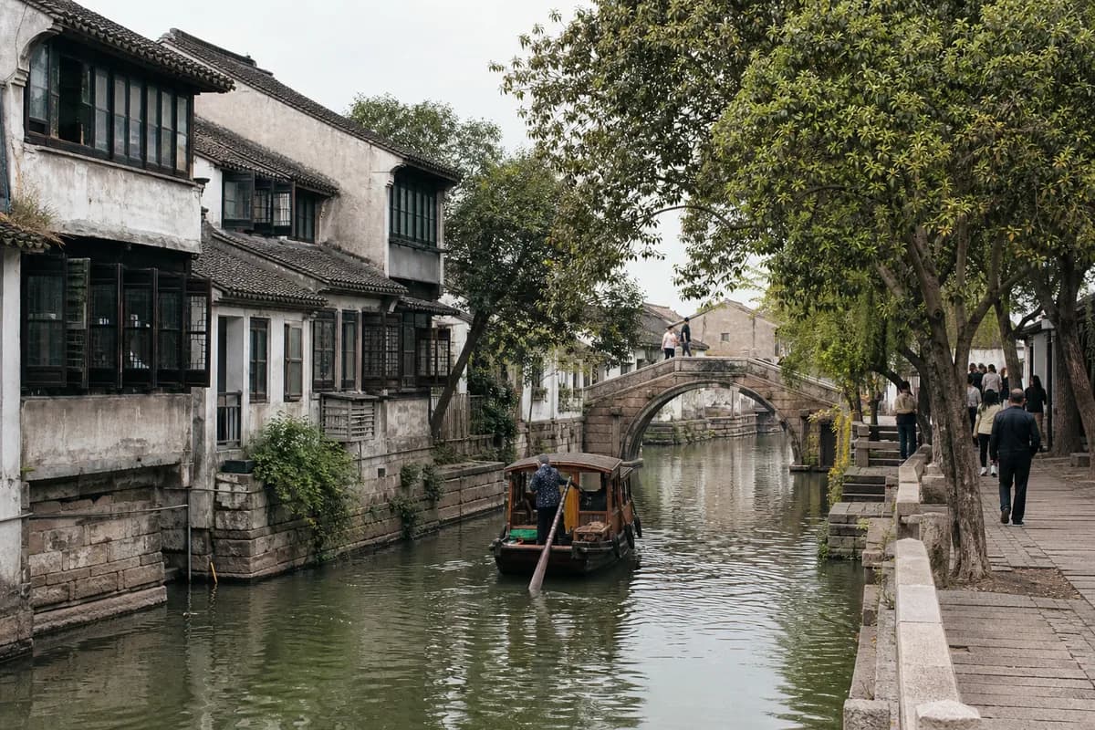 A Suzhou canal, stone bridge, and whitewashed waterside houses.