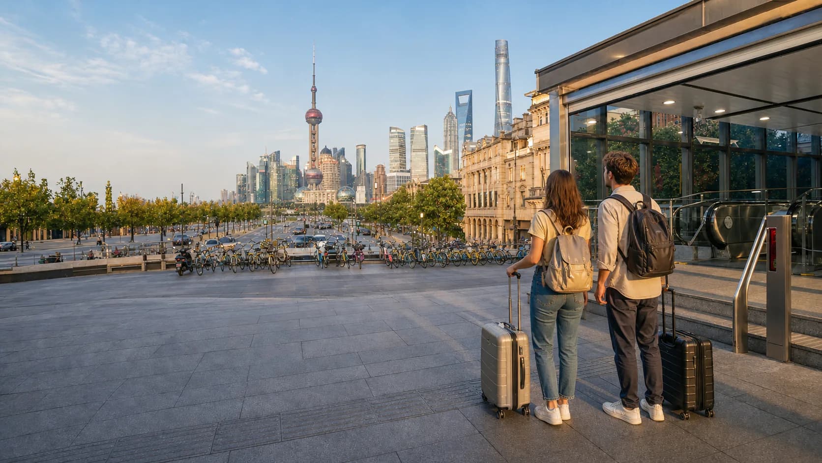 Two young travelers standing beside luggage near a metro entrance with the Shanghai skyline ahead